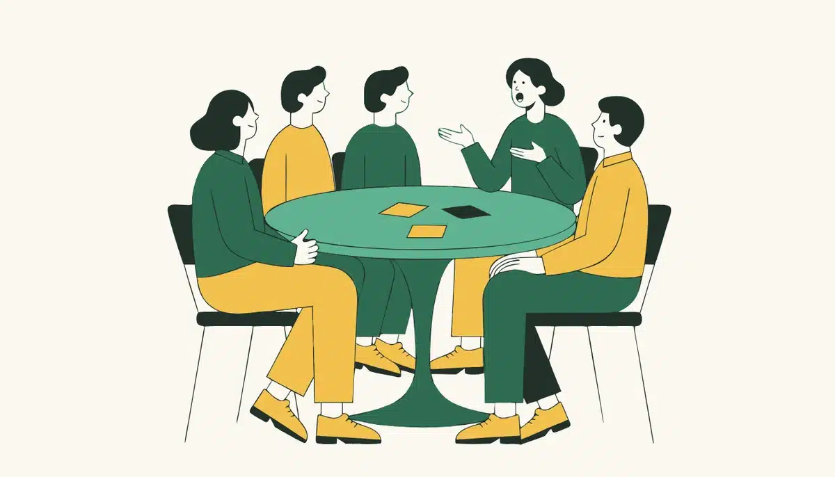 A1 Prüfung Deutsch: Goethe Start Deutsch 1 und telc A1 erklärt 2 Vier Teilnehmende und zwei Prüfende sitzen bei der mündlichen A1 Prüfung an einem runden Tisch und sprechen miteinander.