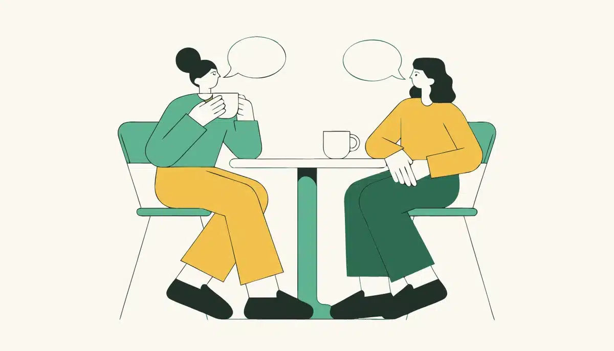 Mündliche Kommunikation (Tandem) 1 Illustration: Zwei Personen unterhalten sich im Café bei einem Kaffee.